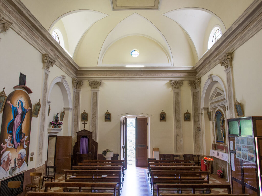 View of church interior facing open entrance door