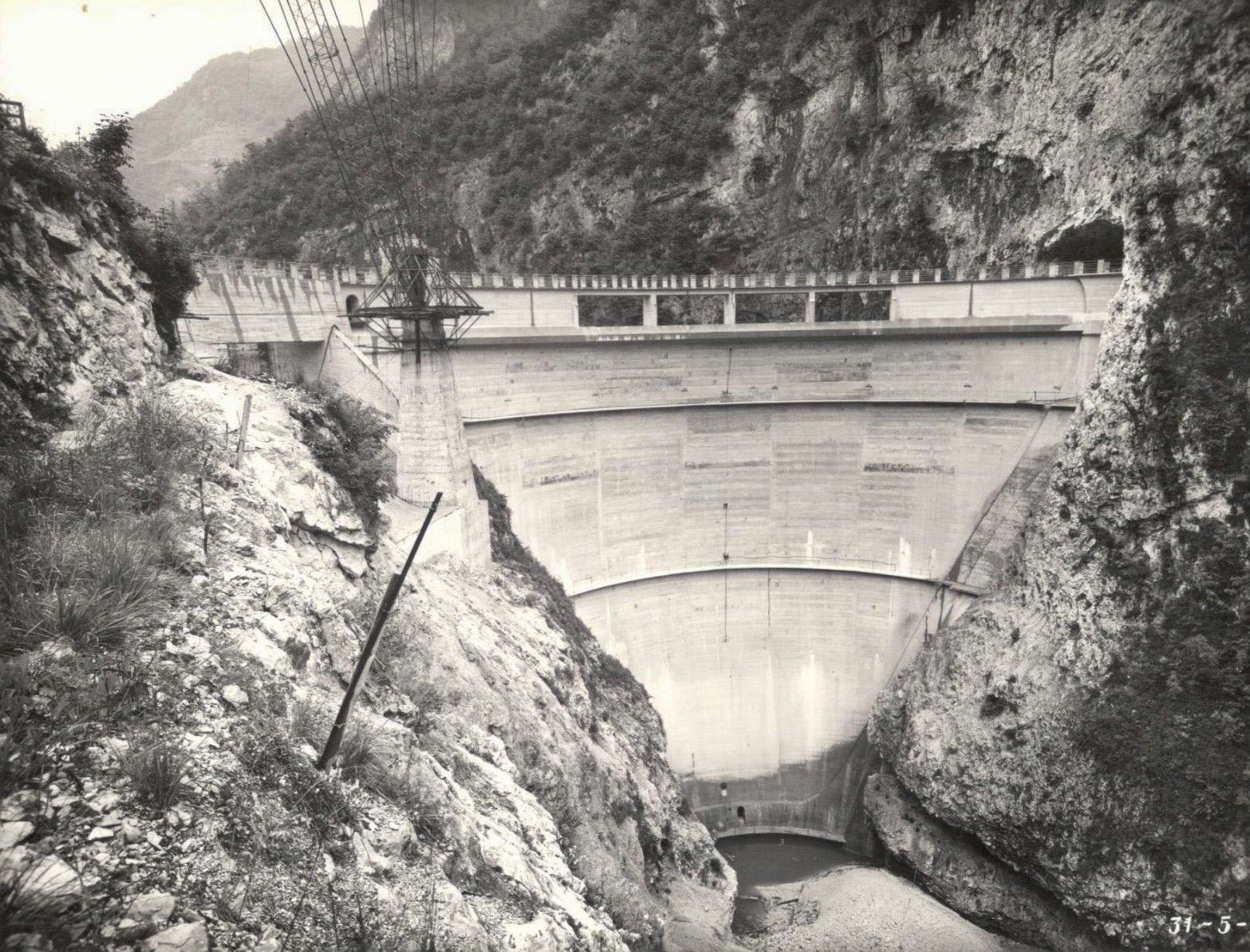 The construction of the Corlo Dam with a crane at left