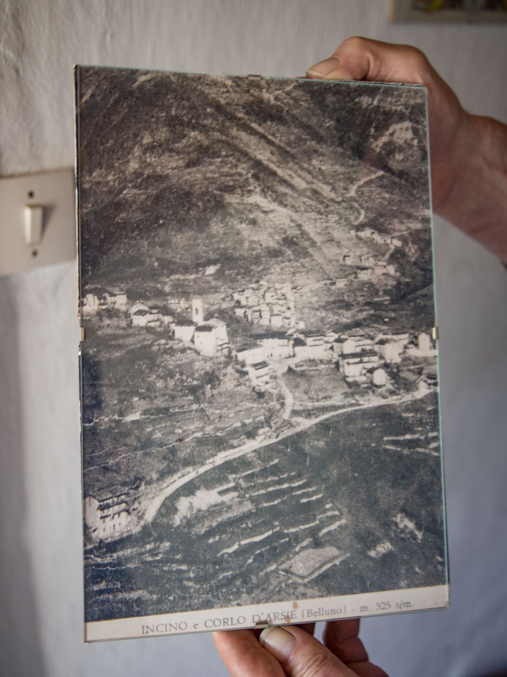 Walter Zancanaro holds large postcard showing Incino from above